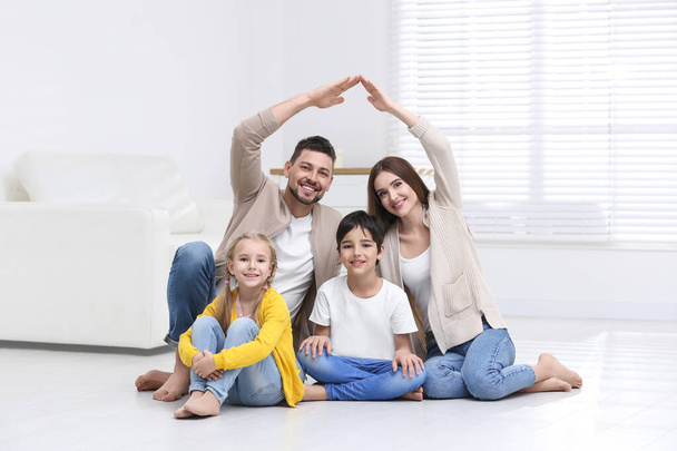 Happy family forming house roof with their hands at home. Insura - Foto, imagen
