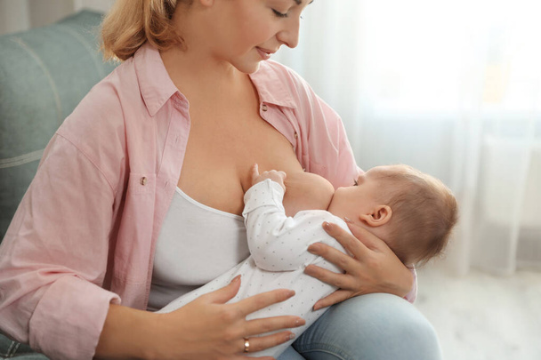 Young woman breastfeeding her baby at home - Foto, Imagen