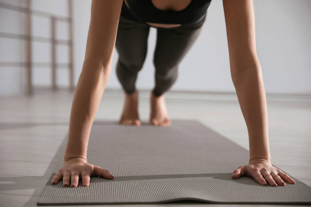 Young woman practicing plank asana in yoga studio, closeup. Phal - Foto, afbeelding