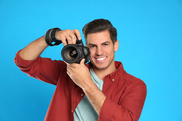 Professional photographer working on light blue background in st - Foto, Imagen