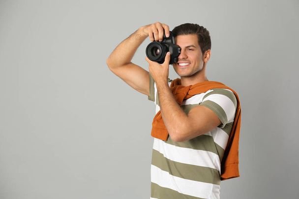 Professional photographer working on light grey background in st - Foto, Imagen