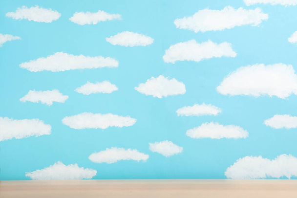 Wooden table near wall with painted blue sky. Idea for baby room - Fotoğraf, Görsel