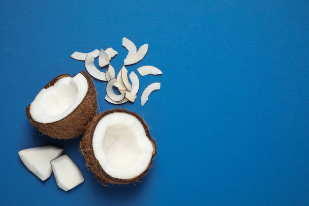 Flat lay composition with tasty coconut chips on blue background. Space for text - Foto, afbeelding