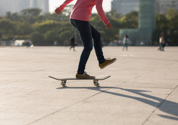 Cropped of female skateboarder riding in urban city - Fotoğraf, Görsel