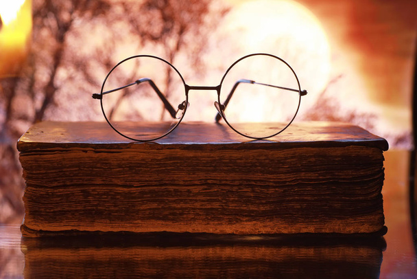 Vintage glasses on an old retro book on a background of the moon - Fotografie, Obrázek