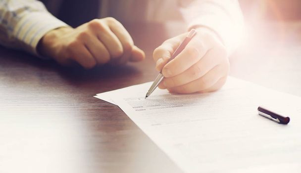 Business meeting. A man signs a contract. Male hand with pen mak - Photo, Image