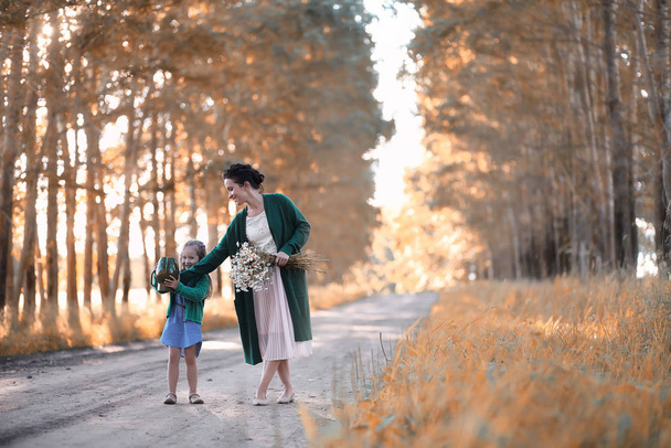 Mère avec sa fille marchant sur une route
 - Photo, image