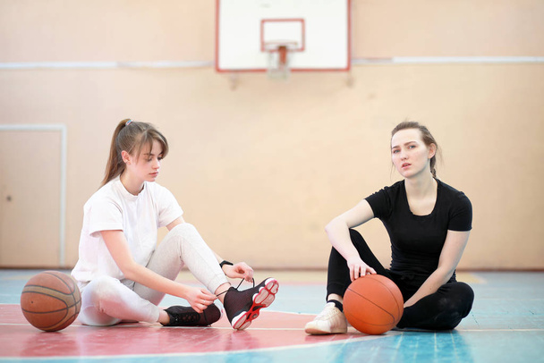 vrouwelijke jonge studenten basketballen in de sportschool  - Foto, afbeelding