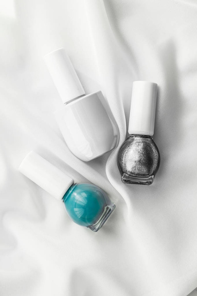 Nail polish bottles on silk background, french manicure products - Photo, Image