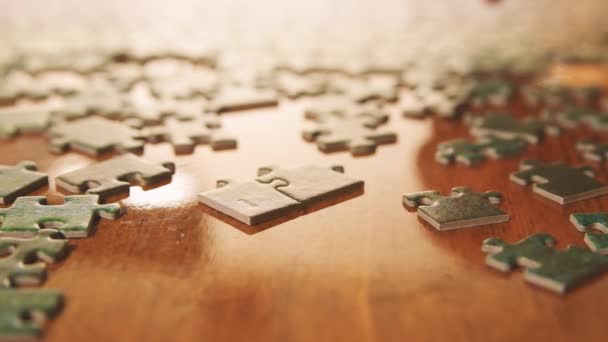 Caucasian male hands assembling jigsaw puzzle pieces. Single pieces and complete puzzle at background. Warm colors - Footage, Video