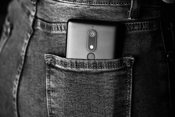 Крупним планом смартфон у джинсах задньої кишені. Бізнес і мода c
 - Фото, зображення