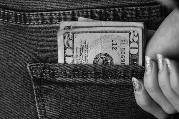 A adolescente pega notas de dólar do bolso de trás. Bankno
 - Foto, Imagem