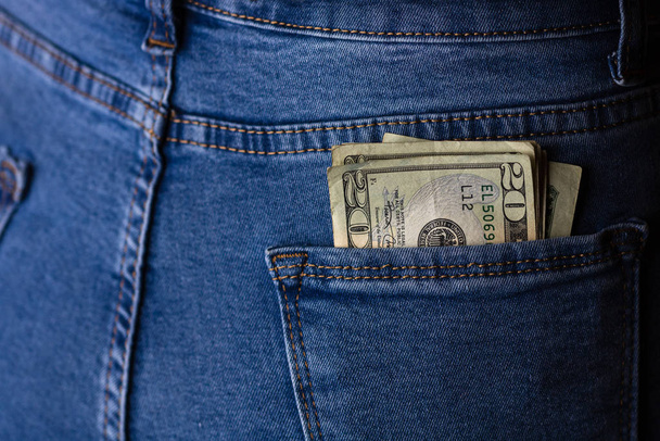 Banknotes close up, money in a jeans pocket. Dollars stick out o - Фото, изображение