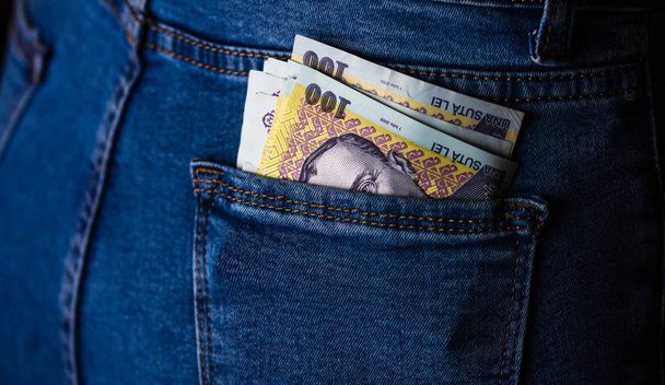 Banknotes close up, money in a jeans pocket. LEI currency stick  - Photo, Image