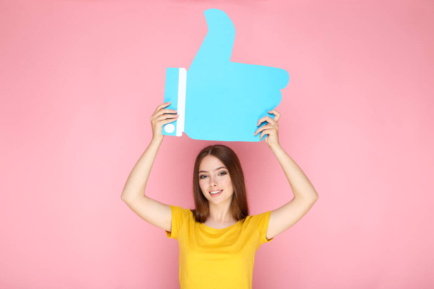 Young woman holding paper Like on pink background - Foto, imagen