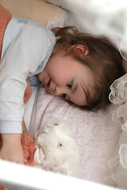 Дівчинка лежить в ліжку на подушці
 - Фото, зображення