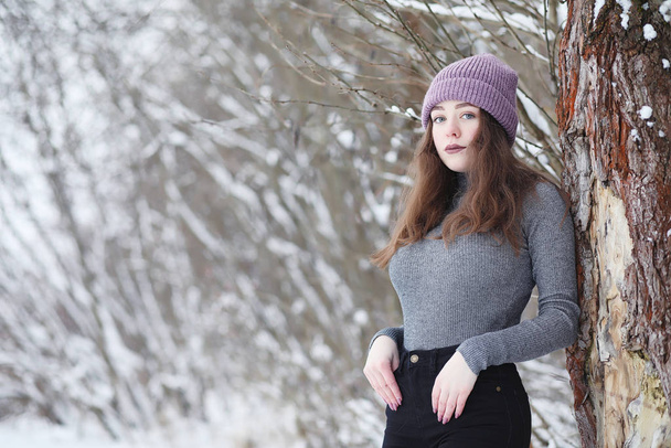 Una joven en un parque de invierno en un paseo. Vacaciones de Navidad en t
 - Foto, imagen