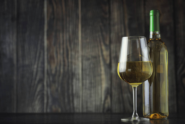 Transparent bottle of white dry wine on the table. White wine gl - Foto, Imagem