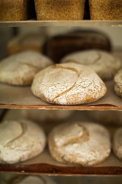 Vertical shot of freshly baked delicious sourdough bread with nice decoration - Fotó, kép