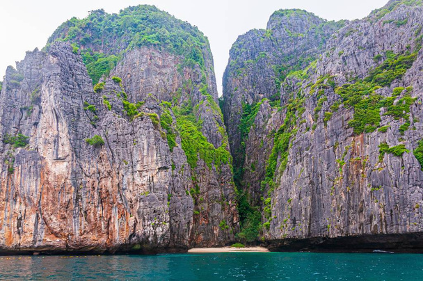Koh Phi Adası 'ndaki temiz okyanus suyuyla etkileşen bir kaya oluşumunun düşük açılı görüntüsü. - Fotoğraf, Görsel
