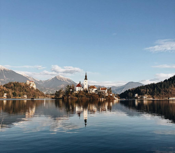 Ancient castle surrounded by a mountainous scenery reflecting in the lake - Foto, afbeelding