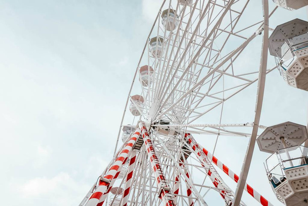 Low angle closeup of the Ferris Wheel carousel with red and white stripes on it - 写真・画像