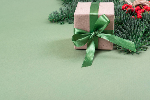 Christmas present with green ribbon and pine branch. - Фото, зображення