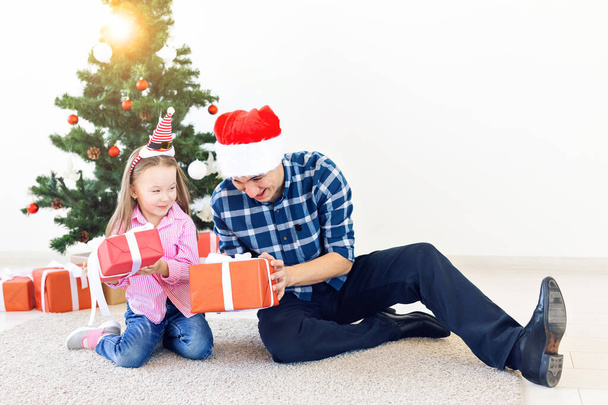 vakantie, kerstmis, familie en geluk concept - vader en dochter met geschenkdoos - Foto, afbeelding