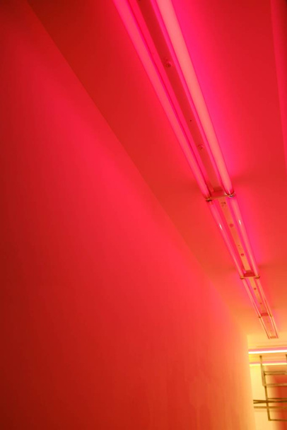 Vertical low angle shot of a hallway with red lamps on the ceiling - Foto, Imagen