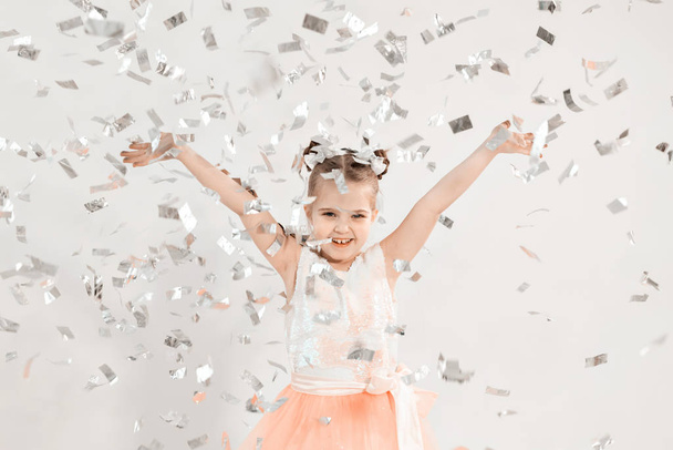 Fête, vacances, anniversaire, nouvelle année et concept de célébration - Mignon enfant lancer confettis
. - Photo, image