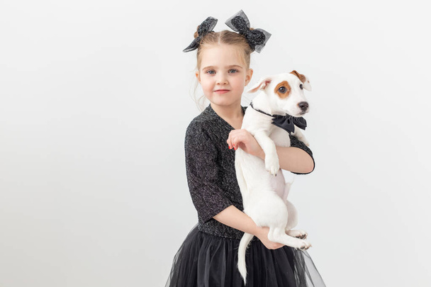 Zwierzęta domowe i zwierzęta koncepcja - dziecko dziewczynka gra z puppy Jack Russell Terrier. - Zdjęcie, obraz