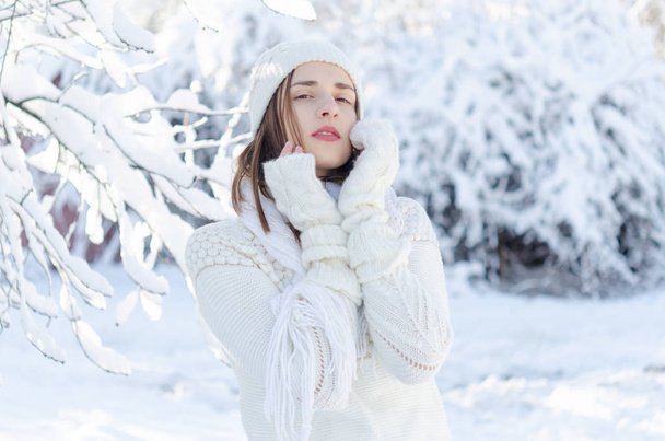 Portrait of young beautiful woman in white warm sweater and hat  - Photo, Image