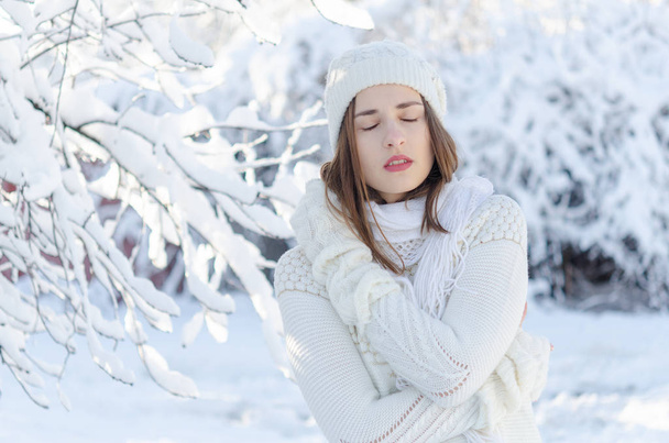 Πορτρέτο της νεαρής όμορφης γυναίκας σε λευκό ζεστό πουλόβερ και καπέλο  - Φωτογραφία, εικόνα