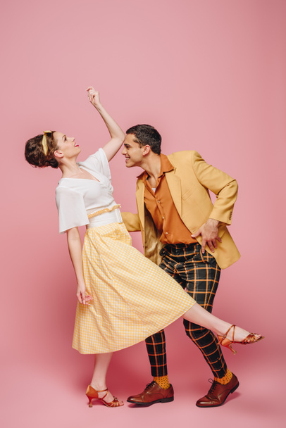 side view of stylish dancers dancing boogie-woogie on pink background - Photo, Image