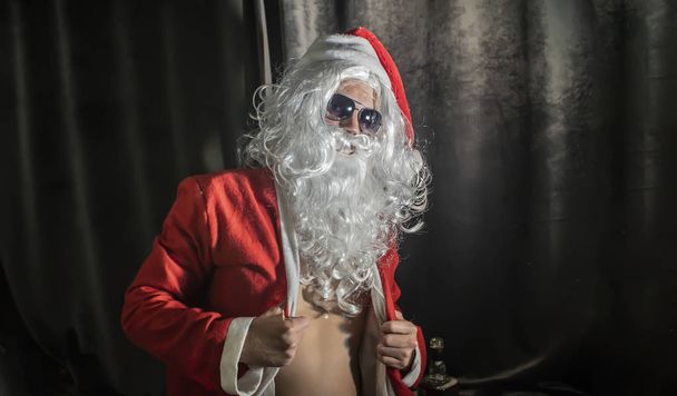 slechte santa man portret op donkere kamer - Foto, afbeelding