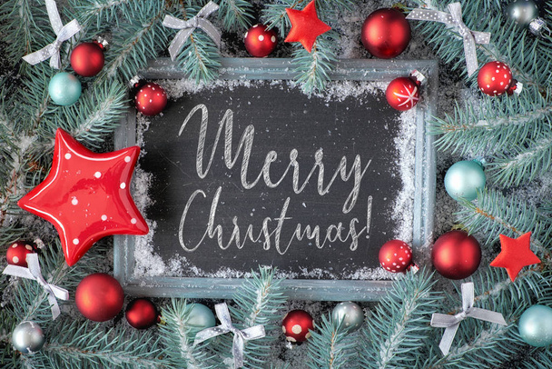 Green and red Christmas background with decorated chalk board. Decorated fir twigs around chalk board on rustic wood with snow. Top view with text "Merry Chtistmas!" - Φωτογραφία, εικόνα