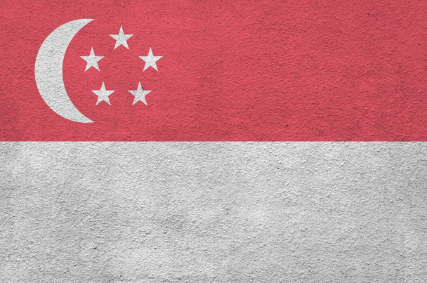 Σημαία Σιγκαπούρης απεικονίζεται σε φωτεινά χρώματα μπογιάς σε παλιό ανάγλυφο σοβάτισμα τοίχο κοντά. Υφή banner σε πρόχειρο φόντο - Φωτογραφία, εικόνα