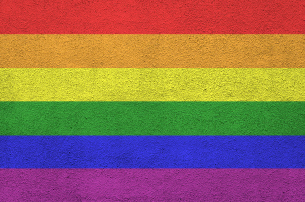 Bandiera della comunità LGBT raffigurata in colori vivaci sulla vecchia parete di intonaco a rilievo da vicino. Bandiera strutturata su sfondo grezzo
 - Foto, immagini