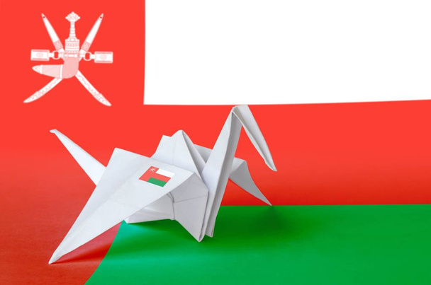 Flaga Omanu przedstawiona na papierowym skrzydle żurawia origami. Orientalna koncepcja sztuki ręcznej - Zdjęcie, obraz
