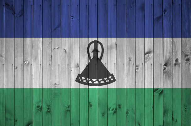Lesotho zászló ábrázolt élénk festék színek a régi fából készült fal közeli. Texturált banner durva háttér - Fotó, kép