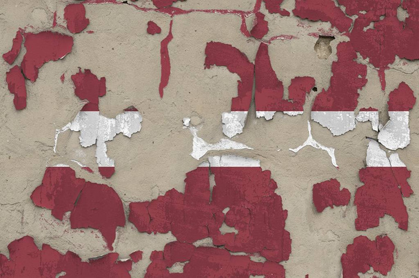 Latvia flag depicted in paint colors on old obsolete messy concrete wall close up. Textured banner on rough background - Photo, Image