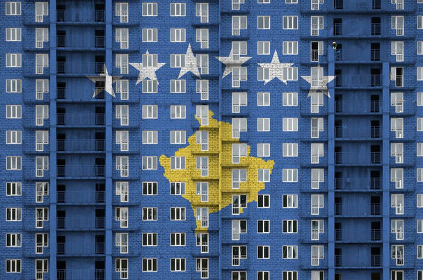 Flaga Kosowa przedstawiona w kolorach farby na wielopiętrowym budynku mieszkalnym w budowie. Baner teksturowany na dużym ceglanym tle ściany - Zdjęcie, obraz