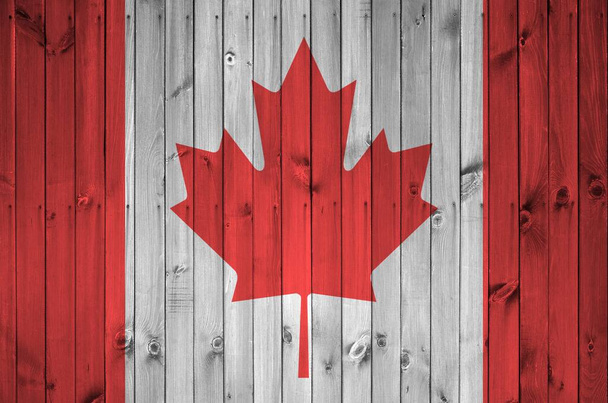 Canada flag depicted in bright paint colors on old wooden wall close up. Textured banner on rough background - Photo, Image