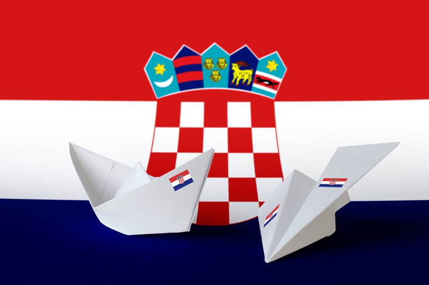 Kroatische vlag afgebeeld op papier origami vliegtuig en boot. Oosterse handgemaakte kunst concept - Foto, afbeelding