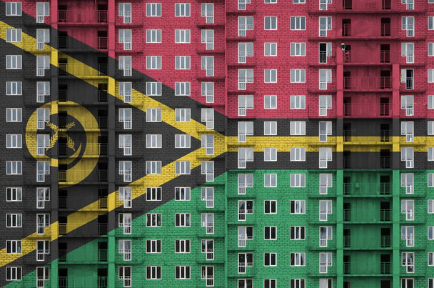 Σημαία Βανουάτου που απεικονίζεται σε χρώματα μπογιάς σε πολυώροφο κτίριο υπό κατασκευή. Πλεκτό πανό σε φόντο μεγάλου τοίχου από τούβλα - Φωτογραφία, εικόνα