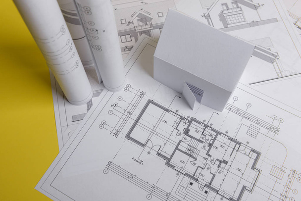Beyaz aile kağıt evi, ev projeleri planı ve arka planda planlar. Minimalist ve basit bir kavram, tarz. Yatay oryantasyon. Yukarıdan görüntüle - Fotoğraf, Görsel