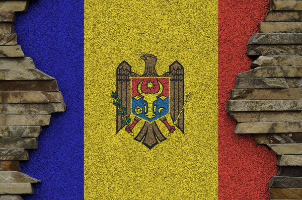 Μολδαβία σημαία απεικονίζεται σε χρώματα χρώμα στο παλιό πέτρινο τοίχο από κοντά. Πανό υφασμένο σε φόντο πέτρινου τοίχου - Φωτογραφία, εικόνα