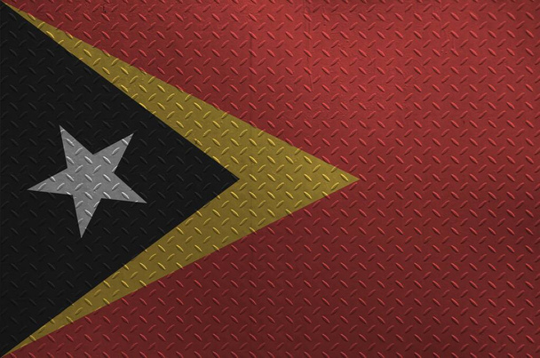 Flaga Timor Wschodni przedstawiana w kolorach farby na starej szczotkowanej metalowej płycie lub ścianach z bliska. Baner teksturowany na szorstkim tle - Zdjęcie, obraz