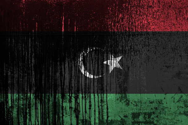 Eine libysche Flagge, die in Lackfarben auf alten und schmutzigen Ölfässern in Großaufnahme abgebildet ist. Texturiertes Banner auf rauem Hintergrund - Foto, Bild
