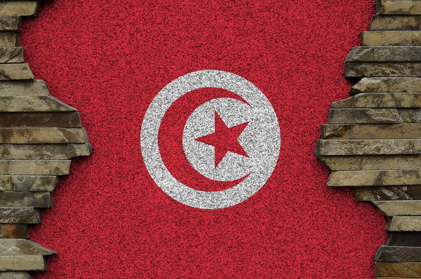 Drapeau de la Tunisie représenté en couleurs de peinture sur un vieux mur de pierre. Bannière texturée sur fond de paroi rocheuse
 - Photo, image
